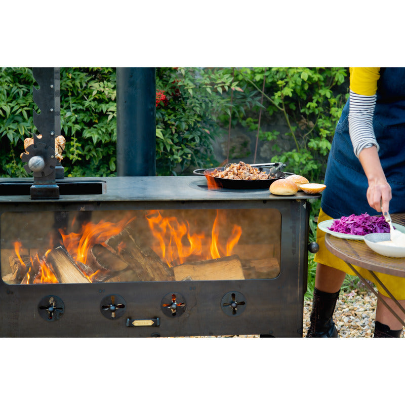 woman cooking on outdoor wood burner