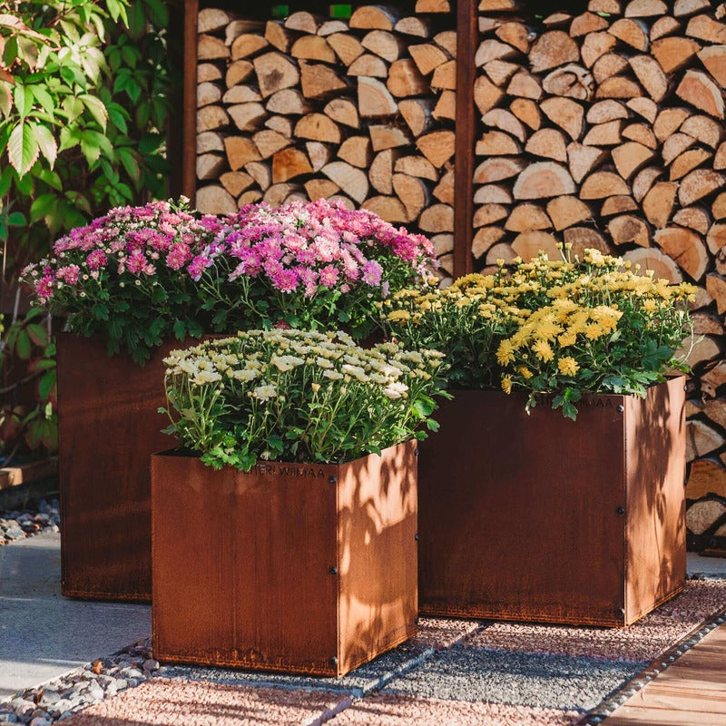 set of corten planters in front of logs