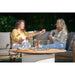 2 women in garden at cosi fire pit table