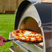 Igneus Pro 600 wood-fired pizza oven removing cooked pizza